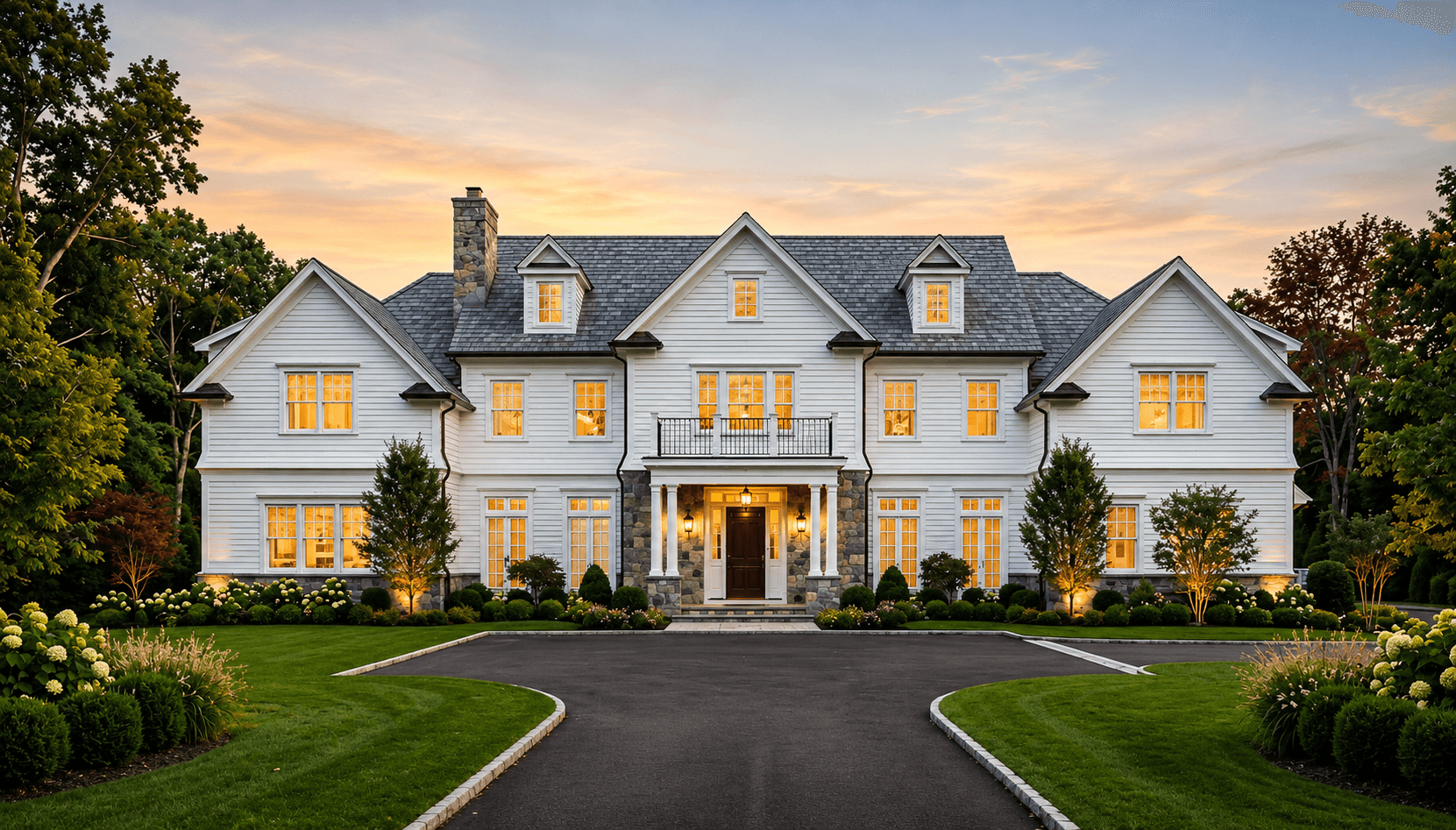 Luxury custom home at dusk with warm interior lighting